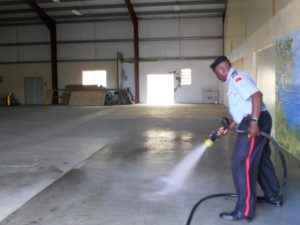 Cleaning_the_facility Local fireman jet hoses the facility